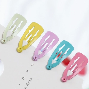Detail of candy-colored wavy hair clips on card in light green, yellow, purple, and blue
