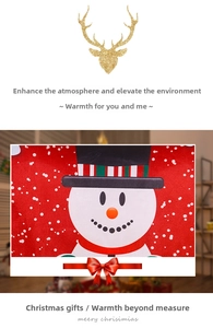 Detail of cartoon snowman print on red Christmas chair cover with gold reindeer accent