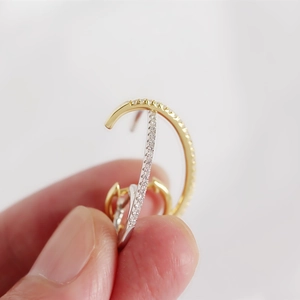 Macro shot of two-tone ear cuff with glittering crystals on minimalist metal bands