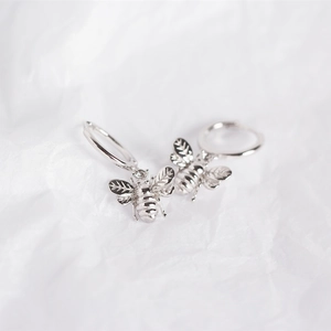 Detailed close-up of S925 sterling silver bee charm earrings on white background