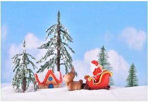 Miniature Christmas landscape featuring Santa, reindeer, snow house and pine trees