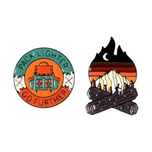 Dettagli di spillette in smalto con zaino da trekking e falò con design di montagna innevata