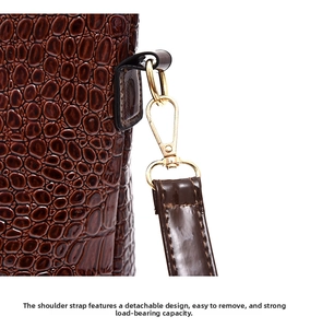 Detail of dark brown crocodile embossed bag with detachable golden metal hook and strap