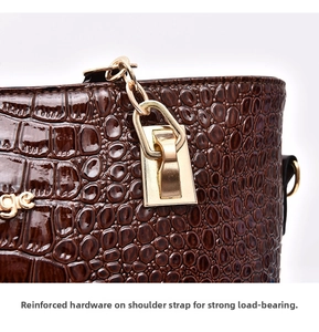 Detail of gold metal hardware and crocodile texture on dark brown leather handbag