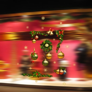 Detail of Christmas window stickers with golden balls, bells and holly garland