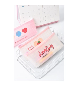 Detailed close-up of pink heart grid stationery bag in a white wire basket setup