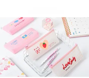 Detail of cute strawberry and milk patterned mesh pencil cases on a white desk
