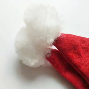 Close-up of a festive red non-woven Christmas hat featuring a soft white faux fur pompom