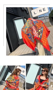 Close-up of red bohemian silk scarf with vintage floral patterns and tassel trim