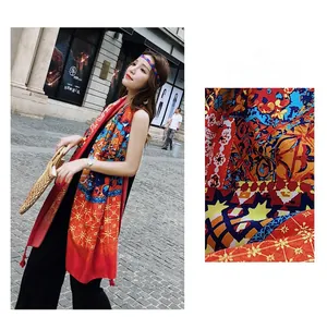 Detail showing bohemian floral patterns and red tassel edges on a long chiffon scarf