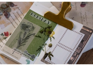Close-up of vintage green floral PET stickers with poems applied to a notebook