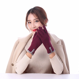 Detail of wine red winter gloves with grey faux fur trim and elegant side buttons