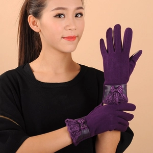 Detail of purple winter gloves featuring lace trim and polka dot bow decoration