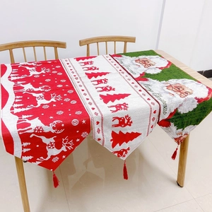 Close-up of Christmas table runners with reindeer patterns and red tassel pendants