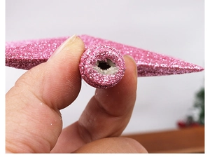 Close-up detail of the circular hole base and pink glitter finish on the star tree topper