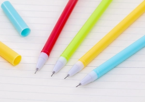 Detailed close-up of four colorful dinosaur gel pens in red green yellow and blue plastic