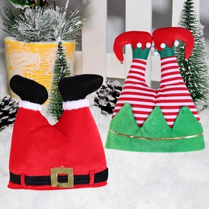 Detail of Christmas Santa pants hat and striped elf hat in a snowy holiday setting