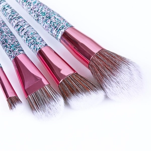 Detail view of 4 pink makeup brushes with dual-tone fiber bristles and glittery handles