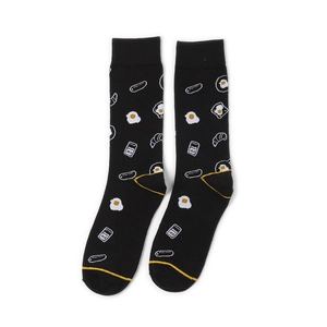 Detail of black mid-calf socks featuring breakfast patterns like eggs and croissants