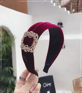 Detail view of burgundy velvet headband with sparkly rhinestone rectangle buckle decoration