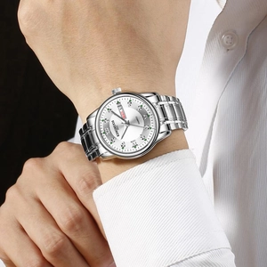Close-up of silver stainless steel watch dial with green markers and day-date display