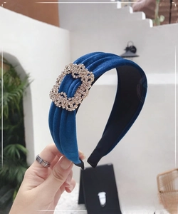 Detail of royal blue velvet headband with sparkling rhinestone buckle and ruched fabric