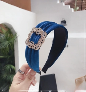 Close-up of a navy blue velvet headband with a sparkling crystal buckle detail