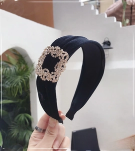 Detail of black velvet headband featuring a sparkling square rhinestone buckle ornament