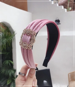 Close-up of pink velvet headband featuring a sparkling rhinestone buckle detail
