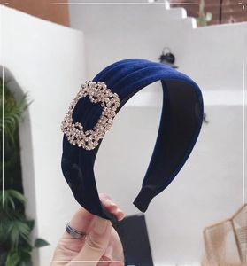 Detail of navy blue velvet headband with a large sparkling rhinestone buckle accessory