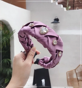 Detail of woven lavender silk headband with sparkling rhinestones in a hand-held outdoor view