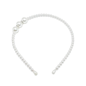 Detail of white faux pearl headband with large beads and sparkling rhinestone spacers