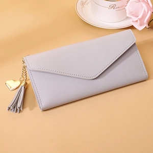 Close-up of lavender envelope wallet with gold heart charm and tassel detail
