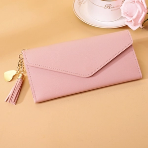 Detail of light pink envelope wallet featuring lychee texture and heart tassel charm