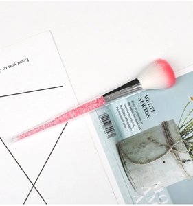 Macro detail of makeup brush with pink crystal-filled handle and soft gradient bristles