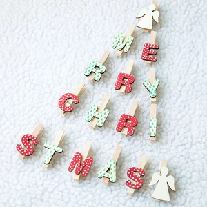 Pinces de Noël en bois avec motifs anges et lettres sur fond blanc texturé doux