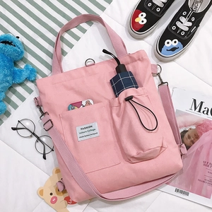 Pink canvas tote bag with adjustable strap and side pockets for casual college style