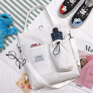 White canvas tote bag with front pocket and side bottle holder for daily leisure use