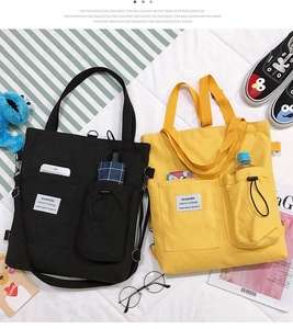 Detail of canvas tote bags showing side pockets and adjustable shoulder straps