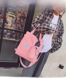 Detail of pink canvas tote showing a convenient side pocket holding a folding umbrella
