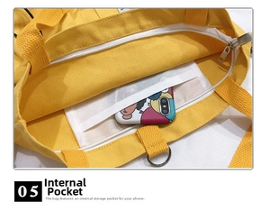 Detail shot of the interior zipper pocket in a yellow canvas bag holding a smartphone