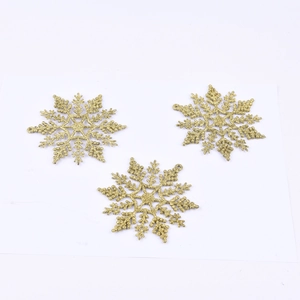Golden glitter snowflake Christmas tree ornaments on white background for holiday decor