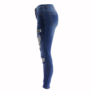 Detailed side view of skinny blue jeans with leopard print patches and ripped knees