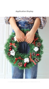 Detail of Christmas wreath with pine cones, cotton, berries, and red plaid bows