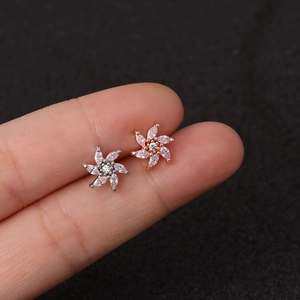 Macro shot of silver and rose gold flower earrings with marquise stones on ear