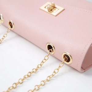 Detail of pink PU leather bag with gold metal chain strap and square turn-lock closure