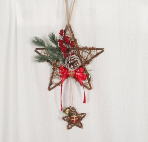 Close-up of a brown rattan star wreath with pine needles, red berries, and gold bells