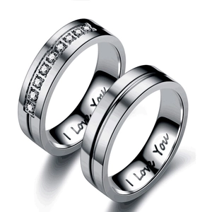 Close-up of titanium steel couple rings with diamond inlay and I Love You engraving