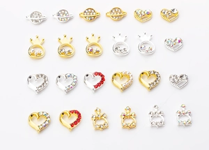 Macro shot of assorted alloy heart, crown, and planet nail charms with pearls and rhinestones