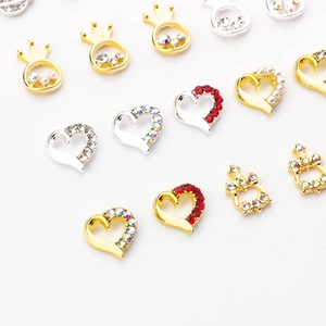 Detailed view of alloy heart and crown nail charms with inlaid diamonds and pearls